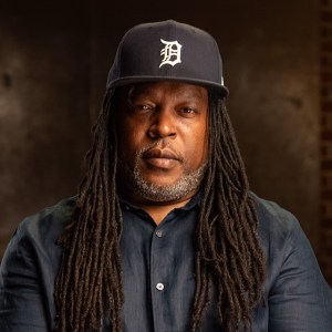 A man with dreadlocks wearing a detroit tigers cap.