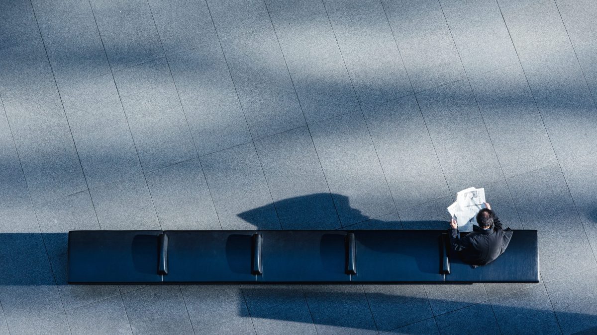 A man sitting alone on a bench illustrating the worker shortage