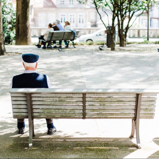 An older man sitting on a bench.