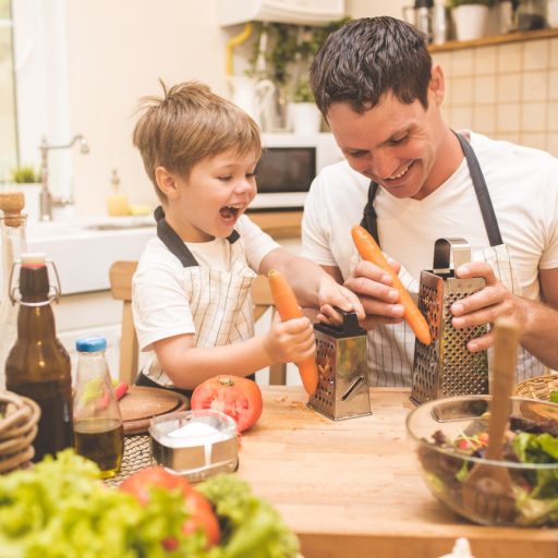 A stay-at-home dad cooking with his son