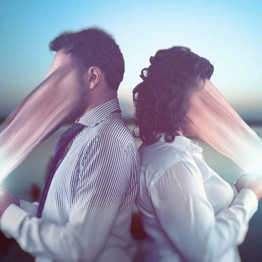 Faces of two people are being absorbed by their phones.