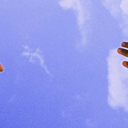 Two hands reaching towards each other against a bright blue sky with clouds, subtly exploring why empathy is bad when it leads to emotional overwhelm.