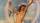 A nude figure with outstretched arms stands against a sky with rainbows and flying birds, evoking a sense of belief in the supernatural.
