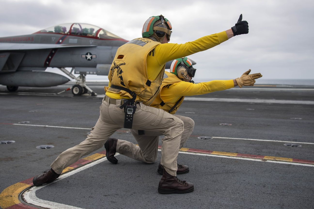 Two shooters from ground crew launch an F/A-18F Super Horent