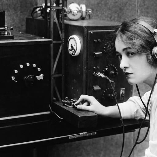 Woman sending Morse code using telegraph