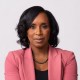 A black woman in a pink blazer.