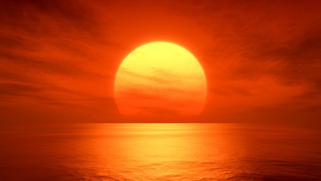 the sun is setting over the ocean on a cloudy day.