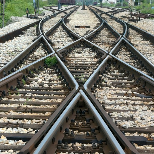 A set of train tracks running through a rural area.