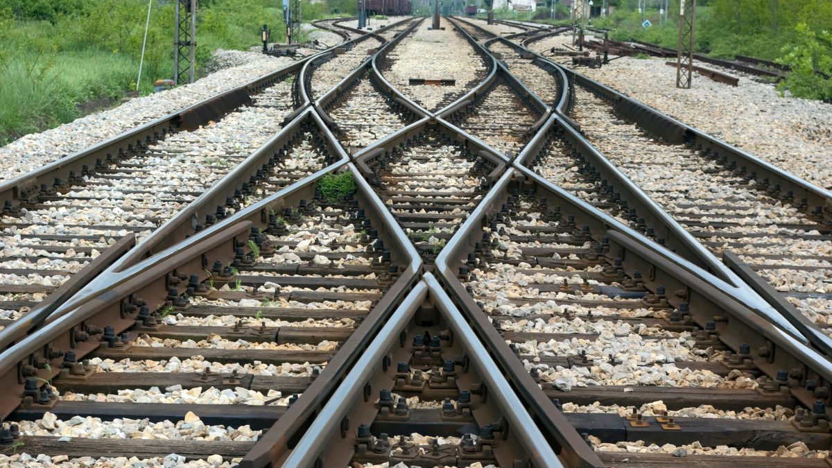 A set of train tracks running through a rural area.