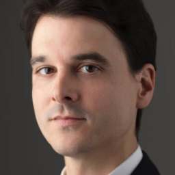 a close up of a person wearing a suit and tie.