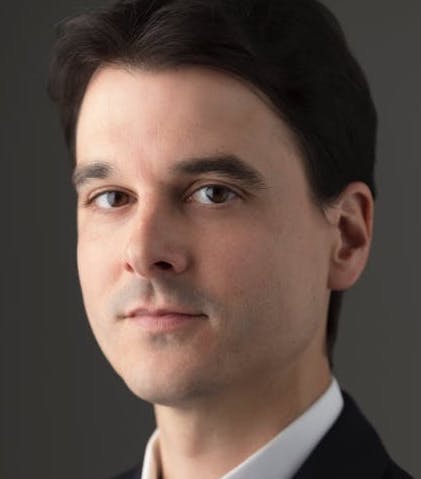 a close up of a person wearing a suit and tie.