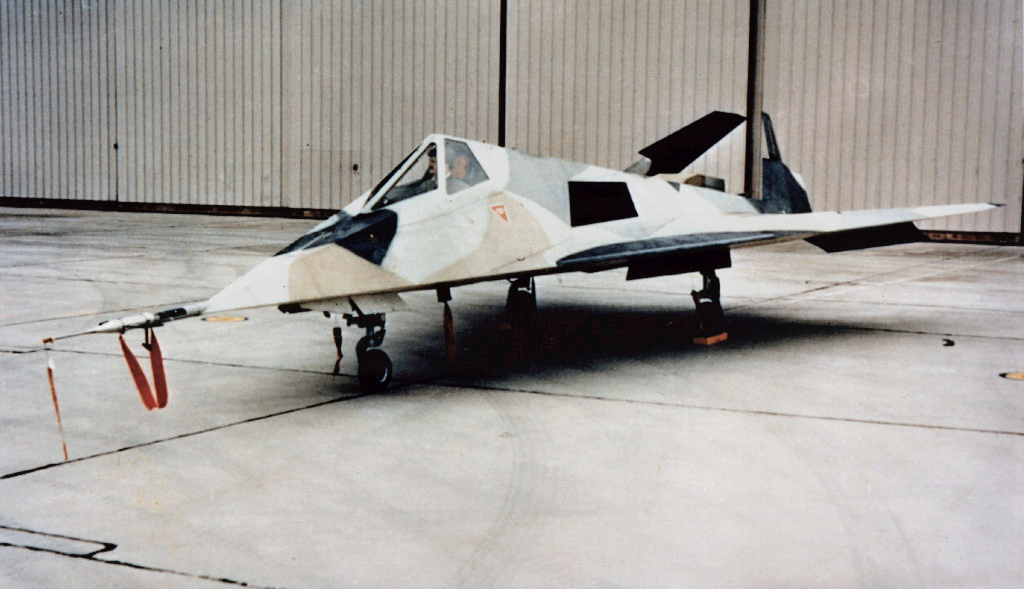 a fighter jet sitting on top of an airport tarmac.