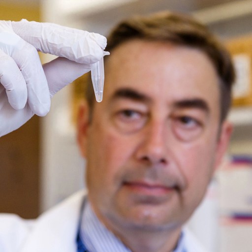 a man in a lab coat holding a test tube