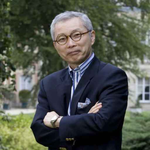 a man in a suit and tie standing with his arms crossed.