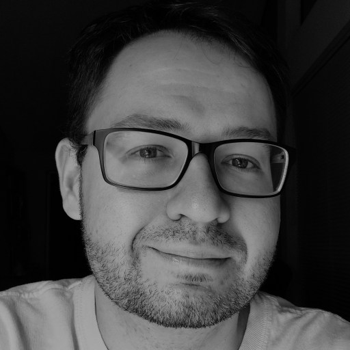 a black and white photo of a man wearing glasses.