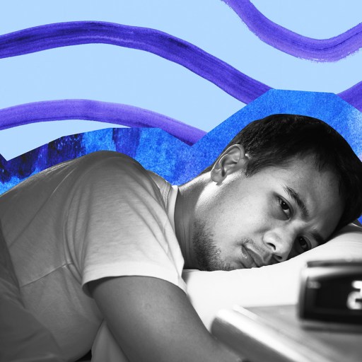 a man sleeping in a bed with a clock.