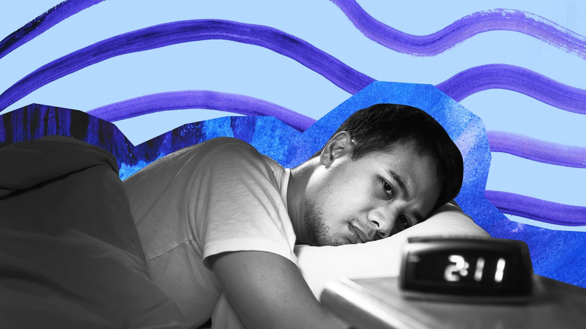 a man sleeping in a bed with a clock.