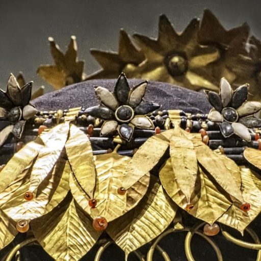 a close up of a hat with gold leaves on it.