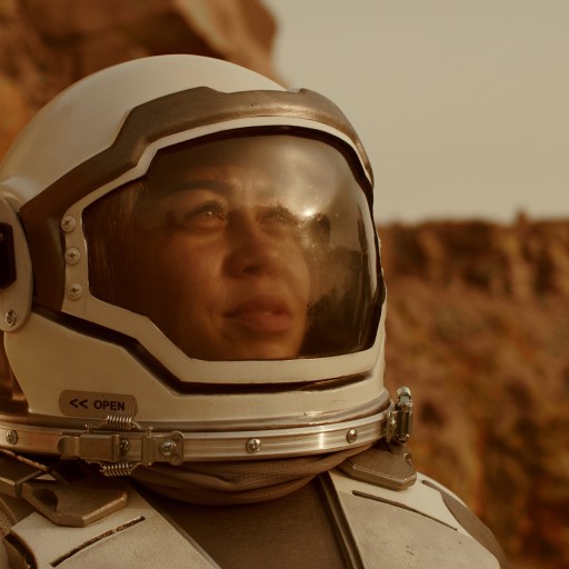 a man in a space suit with a camera in his hand.