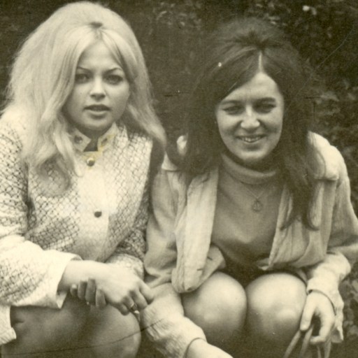 a black and white photo of two women sitting next to each other.
