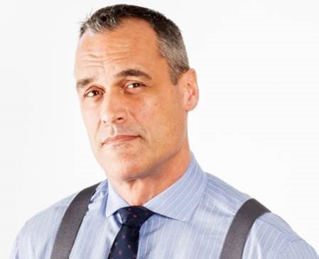 a man in a blue shirt and tie with suspenders.