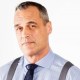 a man in a blue shirt and tie with suspenders.