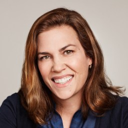 a woman with long brown hair smiling at the camera.