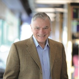 a man in a suit smiling for the camera.