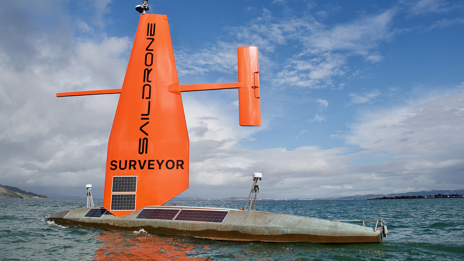an orange boat floating on top of a body of water.