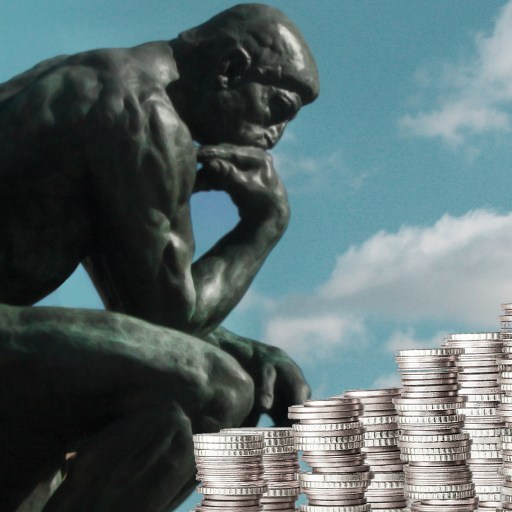 a statue of a man sitting in front of stacks of coins.