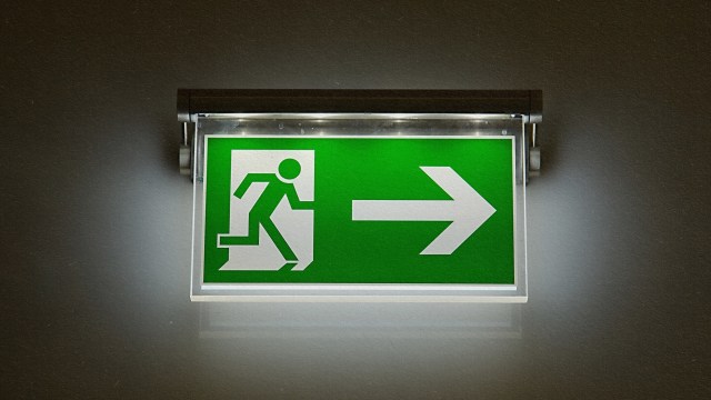 A green exit sign displaying a directional arrow.