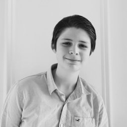 a black and white photo of a person smiling.