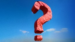 a red question mark kite flying in the sky.