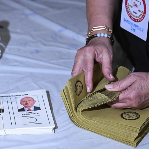 a woman is putting a voting paper in a folder.
