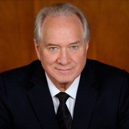 a close up of a person wearing a suit and tie.