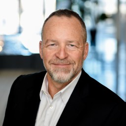 a man in a black jacket and white shirt.