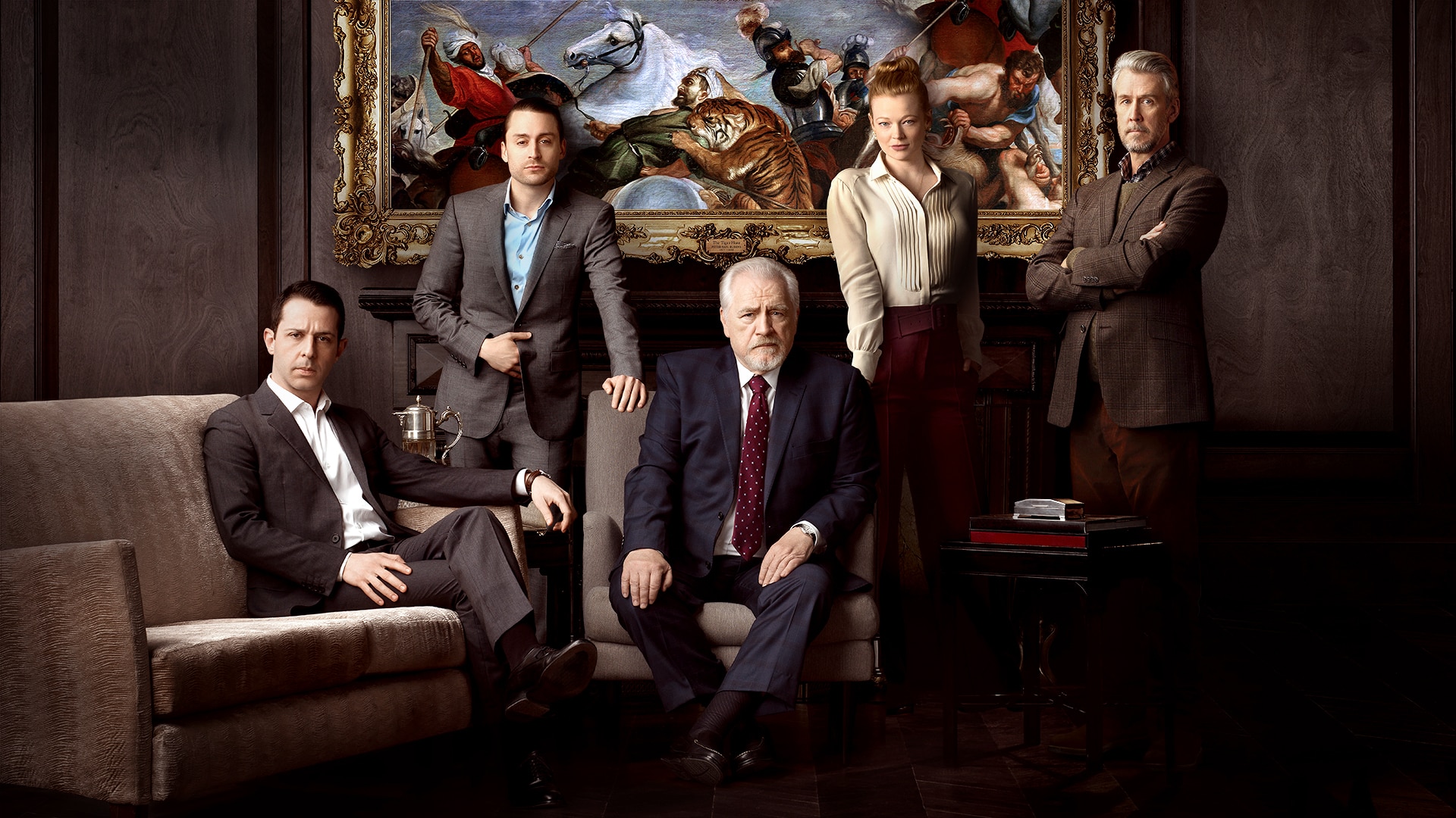 A group of people sitting in front of a painting.