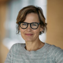 a woman with glasses is smiling for the camera.