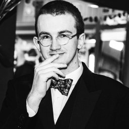 a black and white photo of a man in a tuxedo.