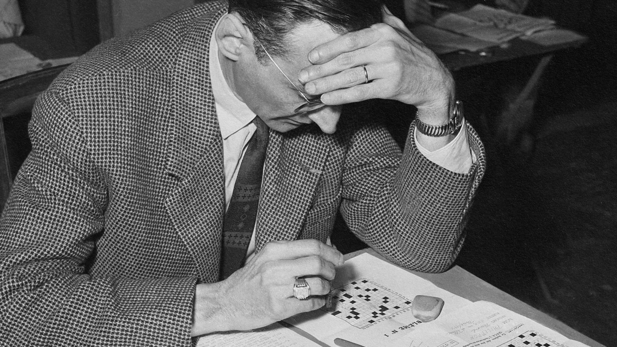 a man sitting at a table with a book in front of him.