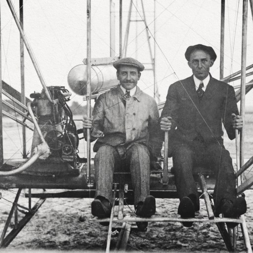 a couple of men standing next to each other in front of a plane.