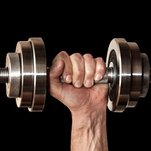 A man's hand holding a pair of dumbbells on a black background.