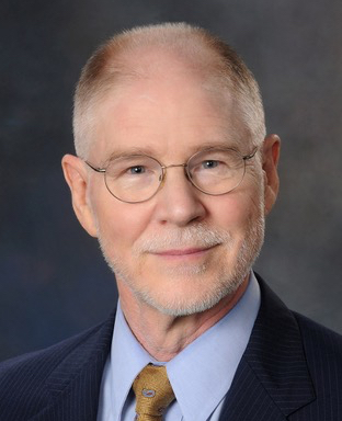 A man in a suit and tie is posing for a photo.