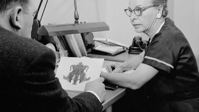 A vintage photo portraying a woman engaged in predictive processing while studying a document.