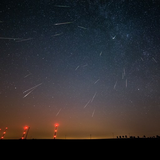 A night sky filled with numerous shooting stars during the Perseid meteor shower.
