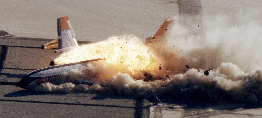 A plane crashes into the ground with smoke coming out of it.