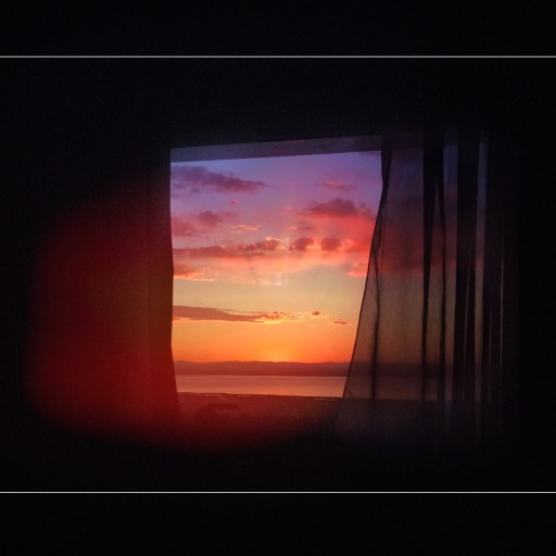 An image of a sunset through a window.