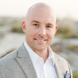 A bald man wearing a suit and tie.