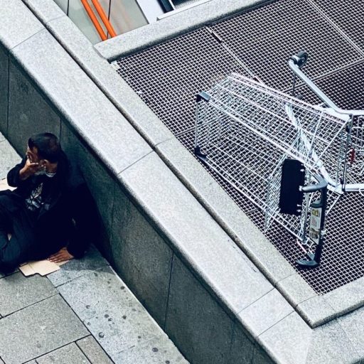 A man is laying on the ground next to an escalator.