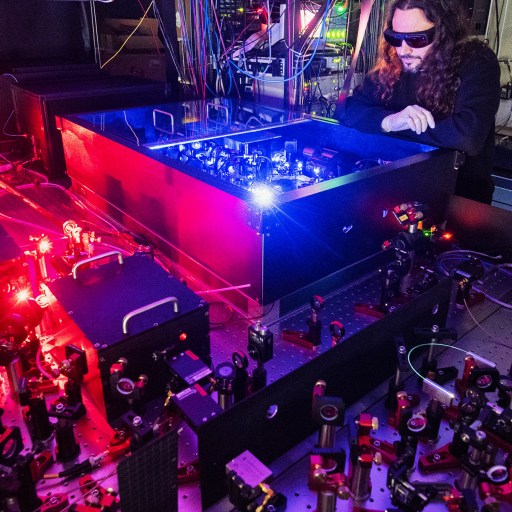 A man exploring quantum computing in a room with red lights.